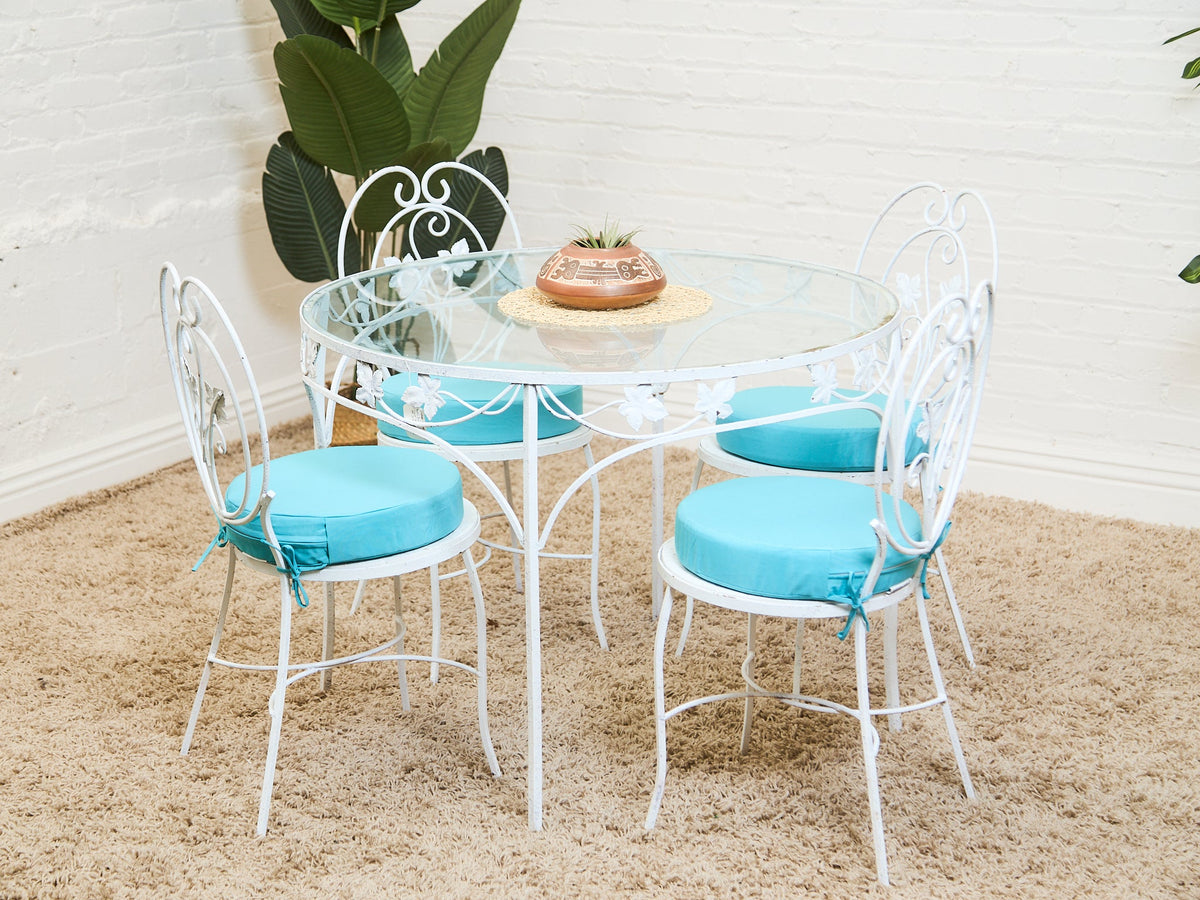 Vintage Wrought Iron Patio Dining Table with Leaf Motif Aqua Cushions and Glass Top