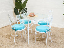 Vintage Wrought Iron Patio Dining Table with Leaf Motif Aqua Cushions and Glass Top