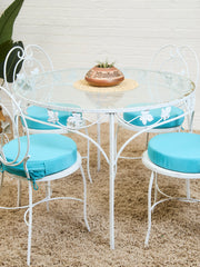 Vintage Wrought Iron Patio Dining Table with Leaf Motif Aqua Cushions and Glass Top