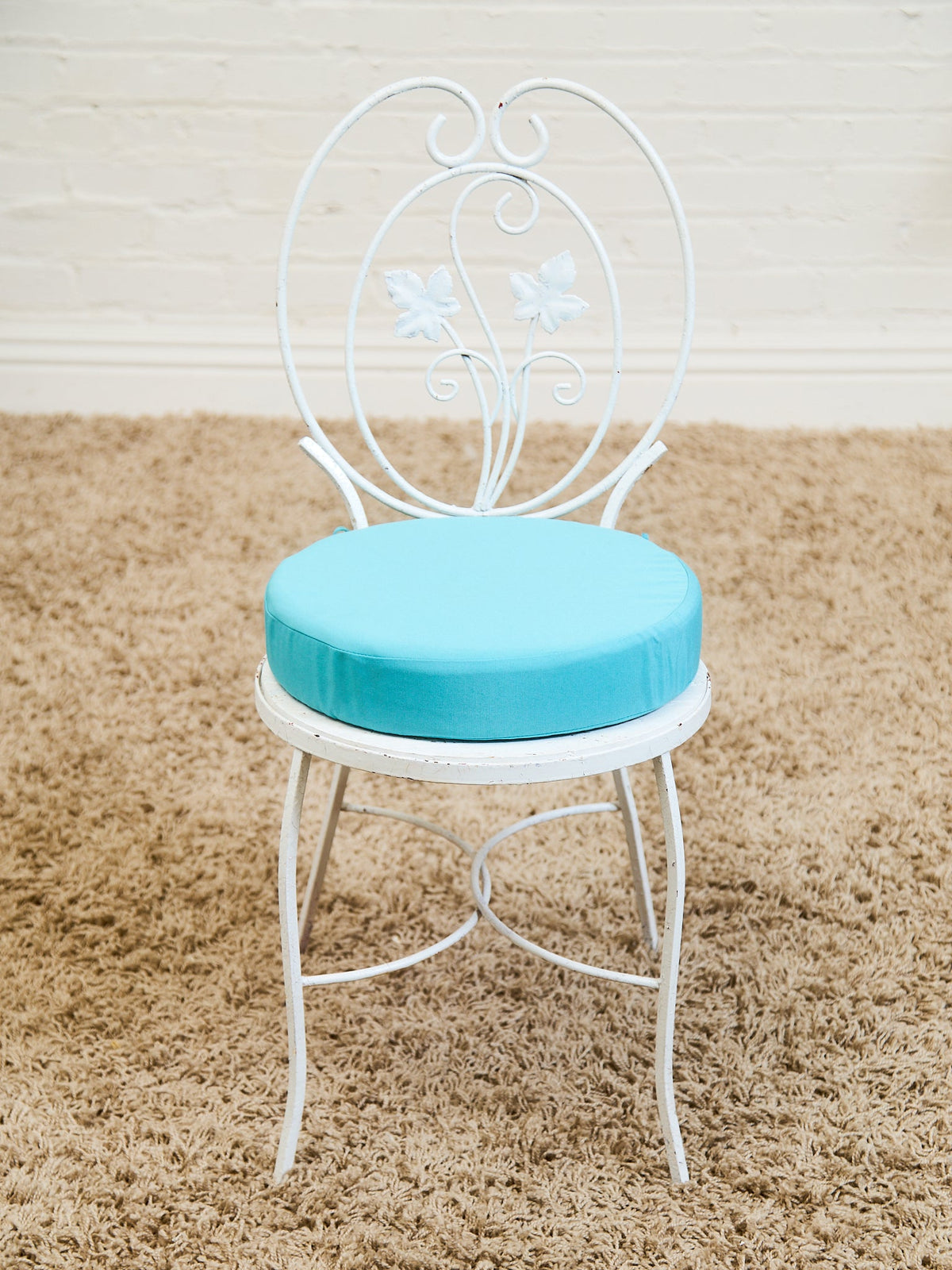 Vintage Wrought Iron Patio Dining Table with Leaf Motif Aqua Cushions and Glass Top