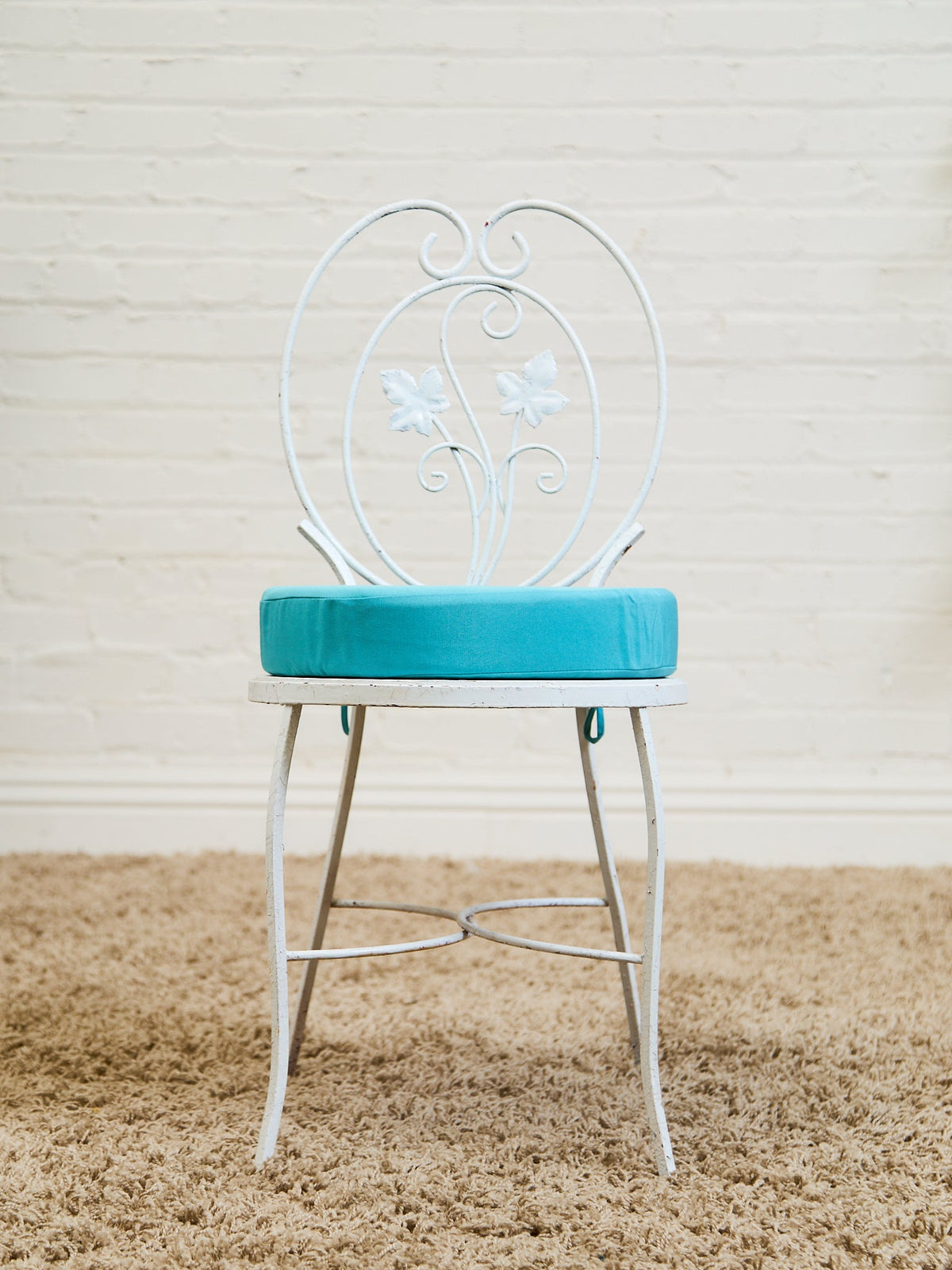 Vintage Wrought Iron Patio Dining Table with Leaf Motif Aqua Cushions and Glass Top