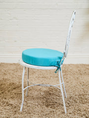 Vintage Wrought Iron Patio Dining Table with Leaf Motif Aqua Cushions and Glass Top