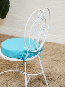 Vintage Wrought Iron Patio Dining Table with Leaf Motif Aqua Cushions and Glass Top